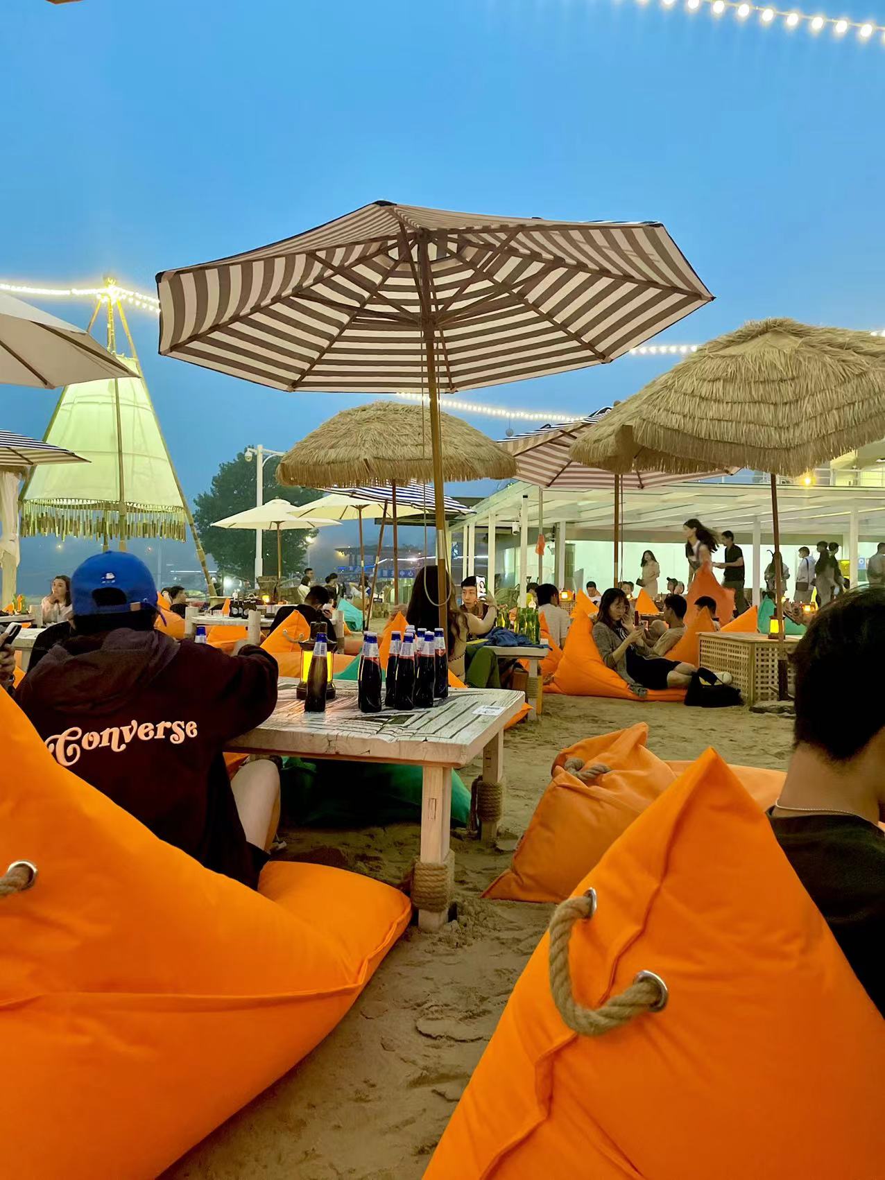 一群年轻人站在海滩上喝啤酒照片摄影图片_ID:317477475-Veer图库
