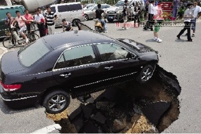 4日，南昌市昌南大道与迎宾北大道交叉口附近路面突然发生塌陷，一辆过路小轿车被卡在洞口处。图/新华社