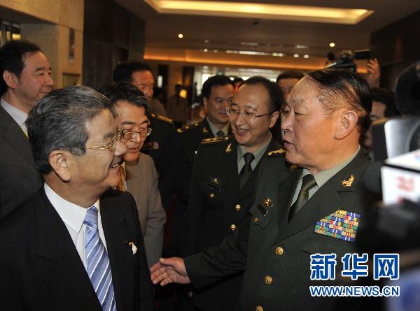 10月11日上午，在越南河内，中国国务委员兼国防部长梁光烈上将（前右）和日本防卫大臣北泽俊美在首届东盟防长扩大会期间进行了交谈