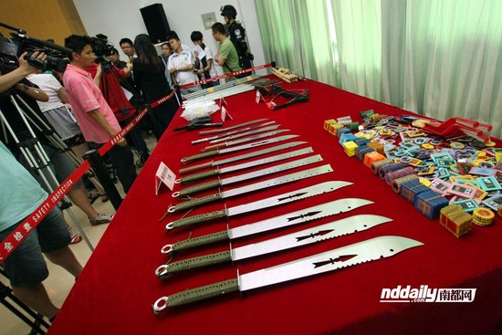 昨日，广州警方展示缴获的仿制枪支和毒品。