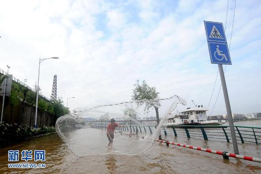 广西多处道路被淹市民路上撒网捕鱼