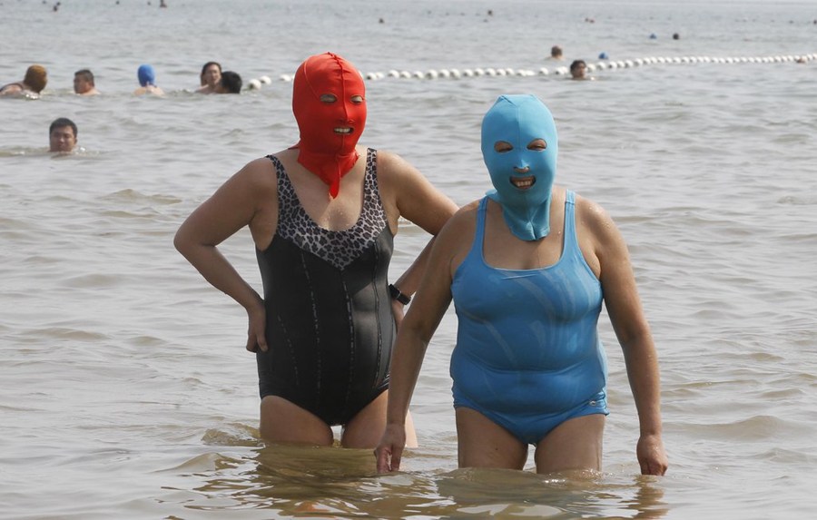 7月6日，山东青岛第一海水浴场，女士们戴着尼龙面罩在海水浴场游泳。