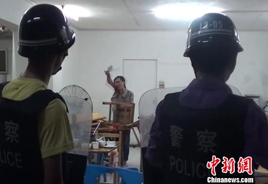 图为涉嫌贩毒的男子持菜刀在宵夜店与民警对峙。 刘志强 摄