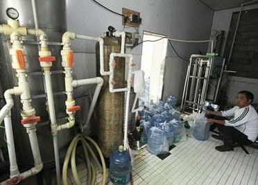 青岛山泉水黑作坊灌露天井水 回收毒桶来装水