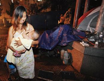 青岛年轻流浪妈妈抱2儿子路边住帐篷 当街安家不愿走