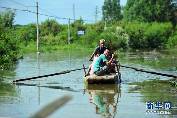 南宁邕江沿岸村庄遭洪灾 居民马路上开船游泳