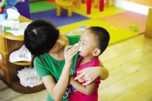 2012年9月3日，浙江一所幼儿园，老师帮孩子擦鼻涕。