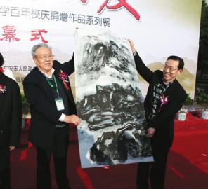 17日上午，曾担任邓小平办公室警卫秘书的张宝忠中将（左）向广安市政府赠送书画作品。