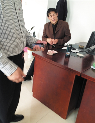 10月29日，献县国税局稽查局办公室内，一名企业主交了两万元现金在桌上。新京报记者 孟祥超 摄