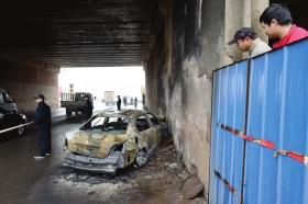 11月29日，香樟路京港澳高速公路桥下，被劫持的小车在逃跑过程中与货车追 尾，起火后烧得只剩下铁架。　　　　　　　　　　　　　　　　　　　　图/记者陈勇