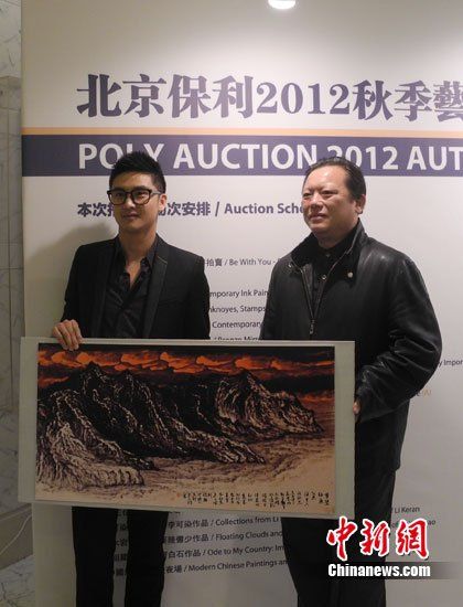 田亮与画家洪潮合影，两人展示《梦萦钓鱼岛》缩小版。
