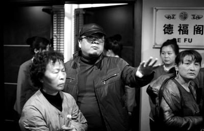 昨日，在河北香河天下第一城，相关负责人（左二）走出会议室与参加演出的老人们沟通。