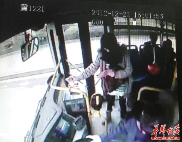公交车监控显示女子将百元钞票一张一张投进投币箱。