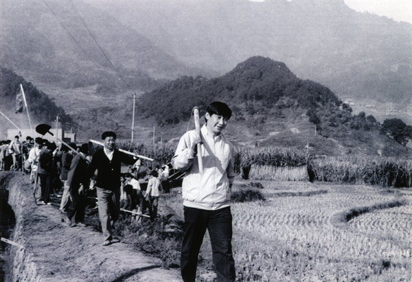 File photo taken in 1988 shows Xi Jinping (front), then secretary of the Ningde Prefecture Committee of the Communist Party of China (CPC), participates in farm work during his investigation in the countryside. (Xinhua)