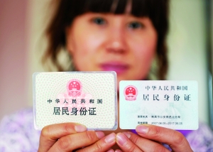 一名上海市民展示两代居民身份证。新华社发