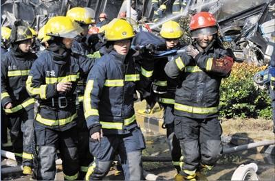 消防官兵将受伤的同事抬出。陈福 摄