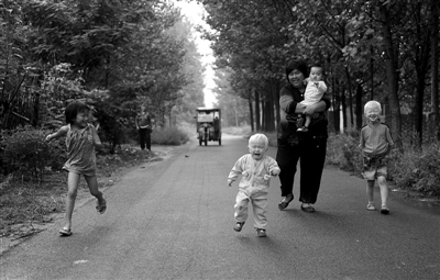 2011年9月7日，河南兰考县，袁厉害时常带着孩子到寄养的人家里相互串门。图/CFP