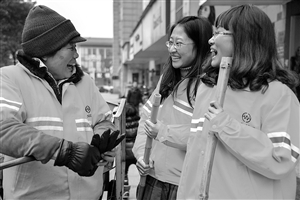 1月8日，22岁的王雪菁（右）和23岁的陶晨露（中）陪着她们的环卫工人师傅邓桂鸾聊天 新华社发