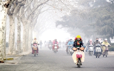 昨天上午，中原路，行人在雾霾中骑车出行，很多行人戴上了口罩。