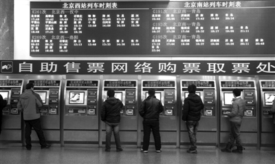 昨日6点，北京西站临时售票点的自助售票机前，旅客正在取票。实习生 王飞 摄