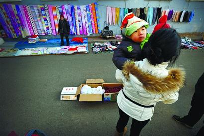 年轻母亲为救3岁脑瘫儿来青 寒风中抱儿摆摊卖枣 年轻母亲为救3岁脑瘫儿来青 寒风中抱儿摆摊卖枣