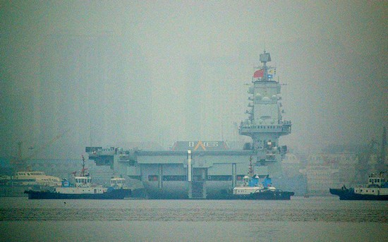 资料图：大连港口大雾弥漫，中国首艘航母“辽宁舰”徐徐离开港口。