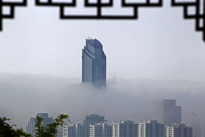 5月10日，青岛，一股平流雾从海上飘向市区上空。沿海的高层建筑悬在半空中，宛如仙境一般
