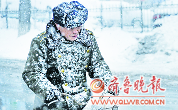 2日上午,烟台一位市民在雪中骑行,身上落满雪花。本报记者　李泊静　摄