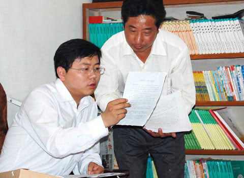 周森锋(左)向村干部询问娃娃菜经营模式