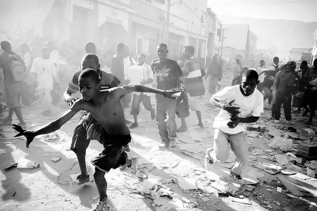 1月17日，在海地首都太子港，抢劫者躲避警方追击。 新华社发