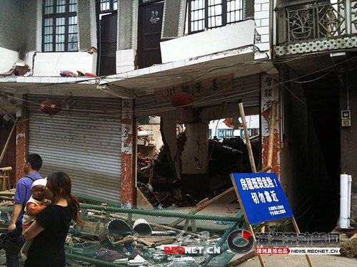 大成桥镇老街，16号门面，房梁垮塌、房屋变形，门前的卷闸门已是一边高一边低。 图/潇湘晨报滚动新闻记者 刘刚