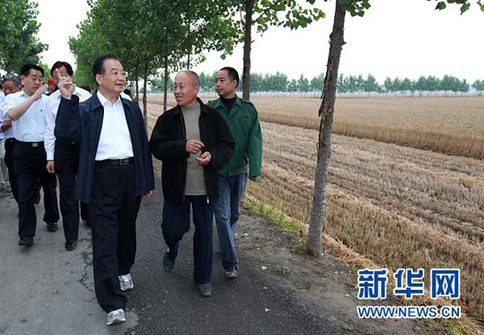 这是6月9日，温家宝在长葛市石象乡坡李王村的田间小路上与坡李王村支部书记李福成边走边聊。新华社记者庞兴雷摄