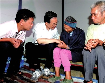 温家宝烈日下察看汛情 泥地里赤手清理砖块