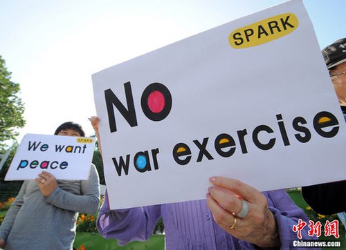 韩美反潜联合军事演习27日在韩国西部海域(黄海)拉开帷幕。当日，一些韩国反战人士在国防部门前集会抗议美韩联合军演。 来源：中央电视台 