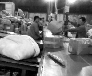 工人抛扔从传送带上抓起的目标包裹