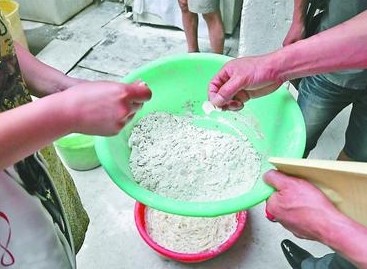 在一家米线加工作坊内，执法人员发现一个盆内盛着白色的粉状物，其中还有不少结块