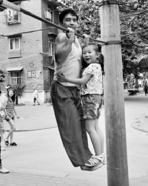 老人脚尖托孙女玩引体向上