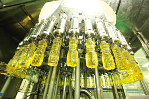 吹好的瓶子转到灌装机上注满玉米油。