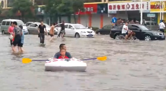临沂暴雨街道成河 公交积水市民驾充气船出门
