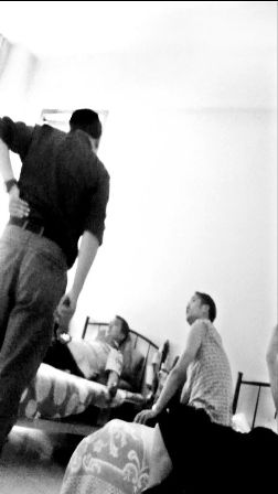 　　王金伍（左一）同躺在床上的民警进行交涉