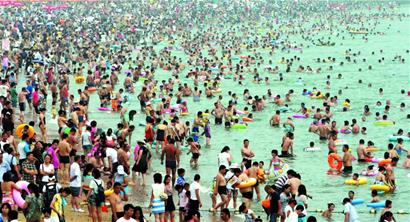 青岛海边游客爆满 一浴10万石老人6万