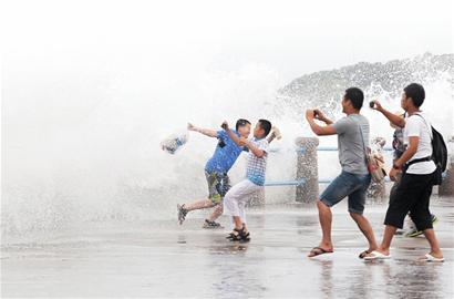 北京女游客不顾巨浪涉险拍照 三勇士营救