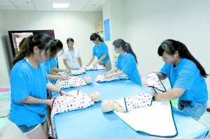 昨日，学生们正在进行给婴儿穿衣服的训练。