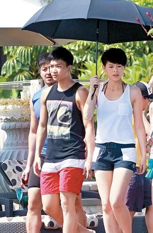 胡杏儿与周志文同撑一把伞遮阳