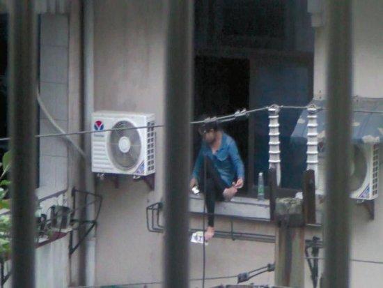 美女坐窗台两个多小时，不时拿起手机看几眼，难道是要跳楼自杀？