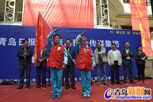 读者节今开幕，市委常委、宣传部长胡绍军为晚报小记者团授旗