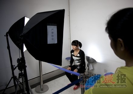 10月22日，长沙市雨花公安分局，赵常玲坐在灯架前拍摄身份证照片