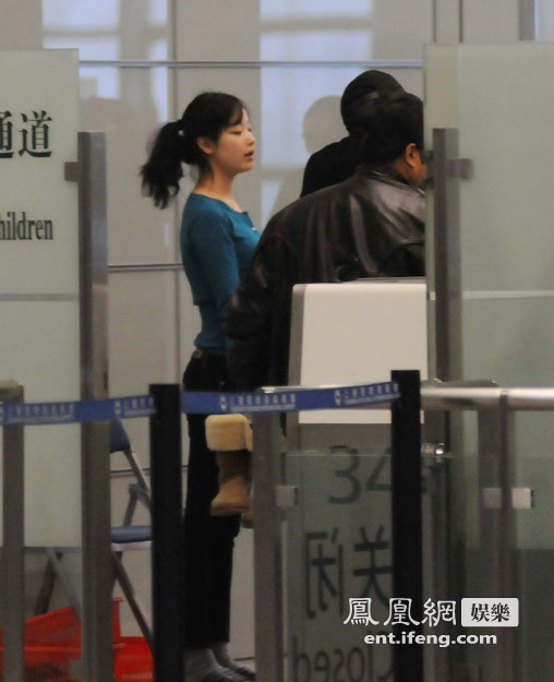 倪妮素颜现身机场遭脱鞋检查 一脸无奈