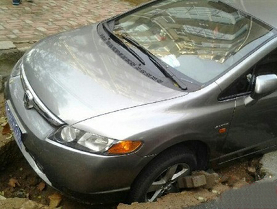 大雨过后青岛一路面塌陷 来往车辆失前蹄
