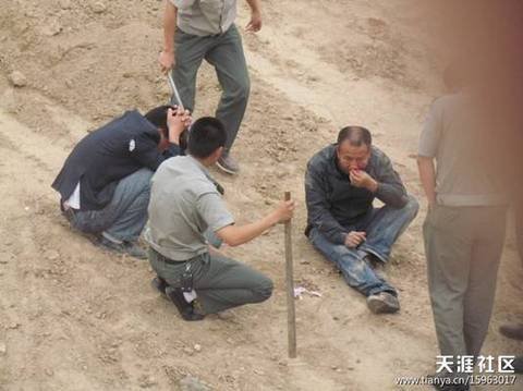 陕AWK707的西安城管执法车和6名穿制服的城管，手持棍棒，在郊外殴打两名倒地男子。 